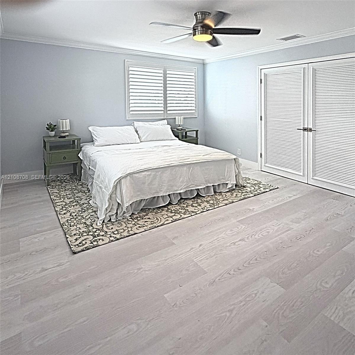 Wood-finish flooring, crown molding, brushed-metal ceiling fan, and double louvered doors