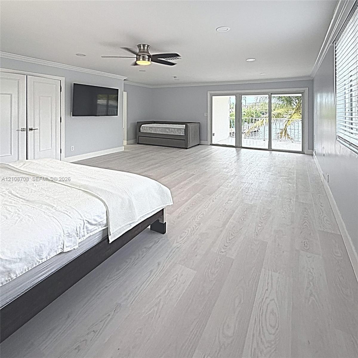 Interior space featuring wood-finish flooring, sliding glass doors, recessed lighting, a ceiling fan, and double-door closet cabinetry