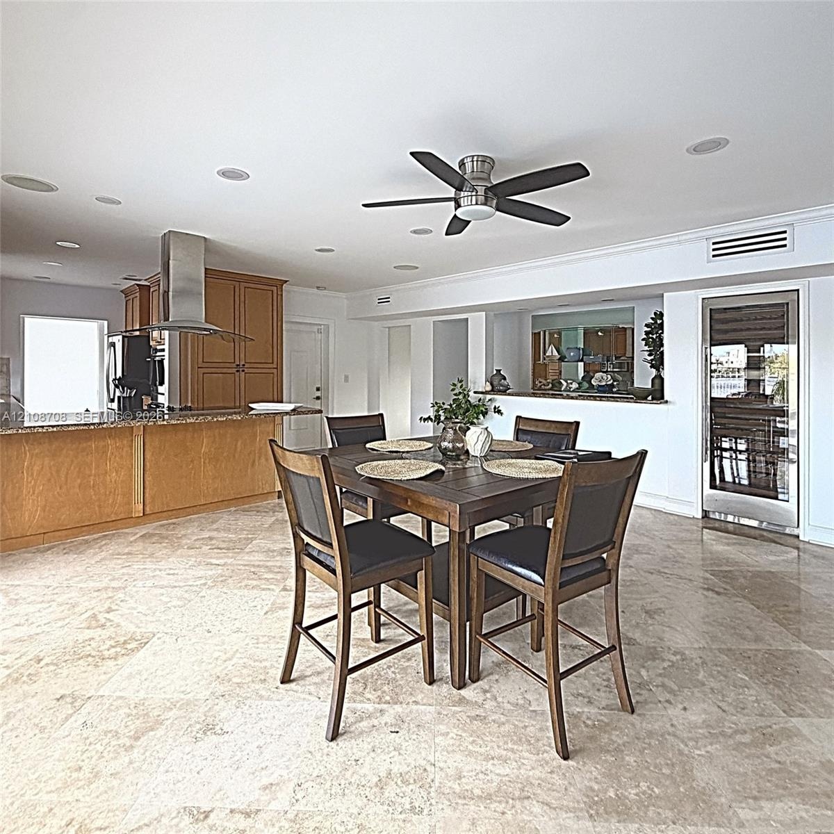 Natural stone flooring, custom wood cabinetry, stainless steel range hood, and built-in wine refrigeration