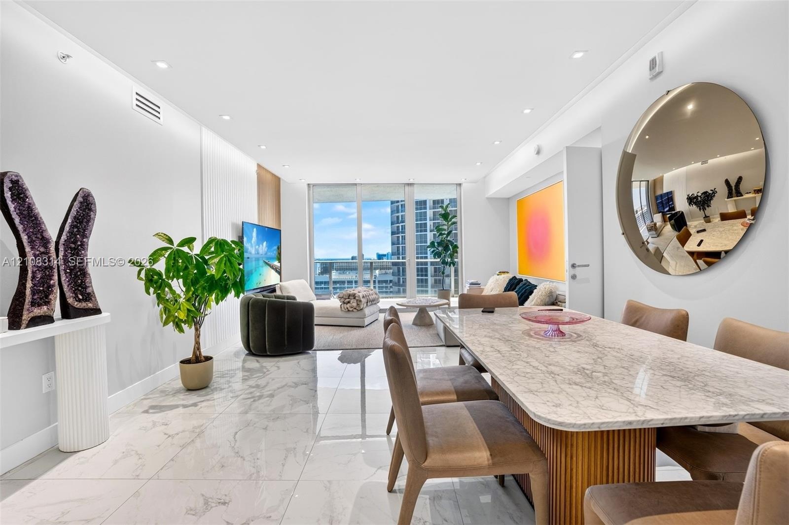 Open-concept living space featuring large-format polished stone flooring, recessed ceiling lighting, and floor-to-ceiling glass windows