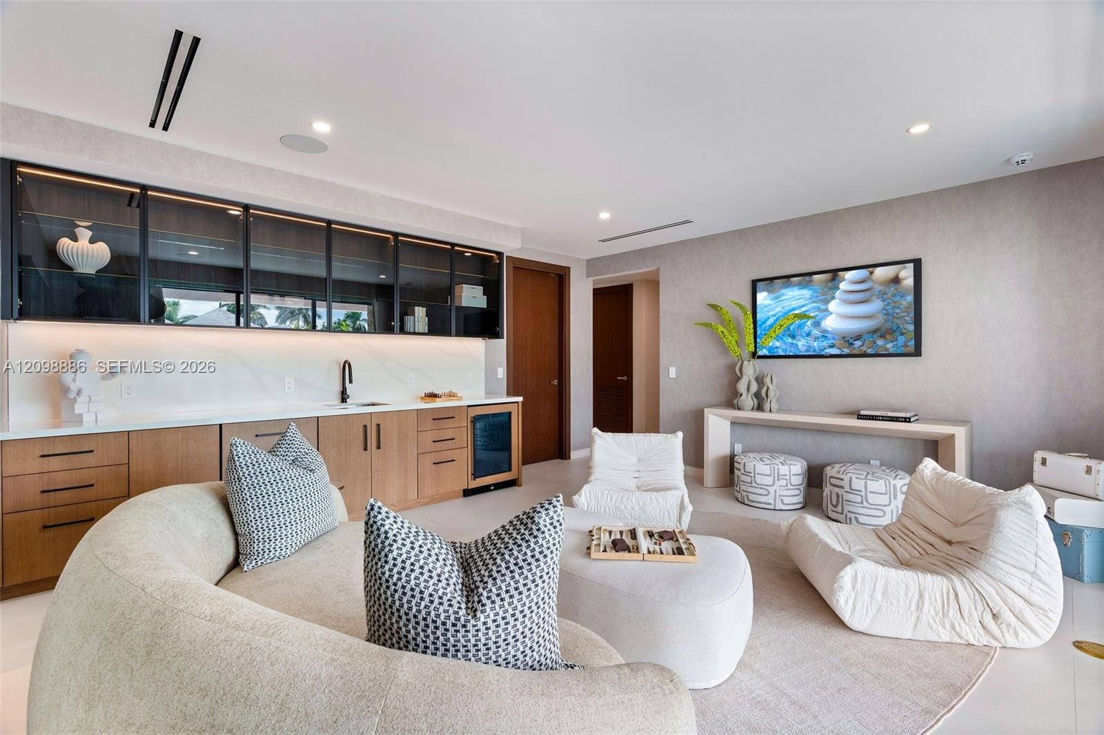 Built-in bar featuring wood cabinetry, stone-surface countertop, under-cabinet lighting, glass-front upper storage, and an integrated beverage refrige