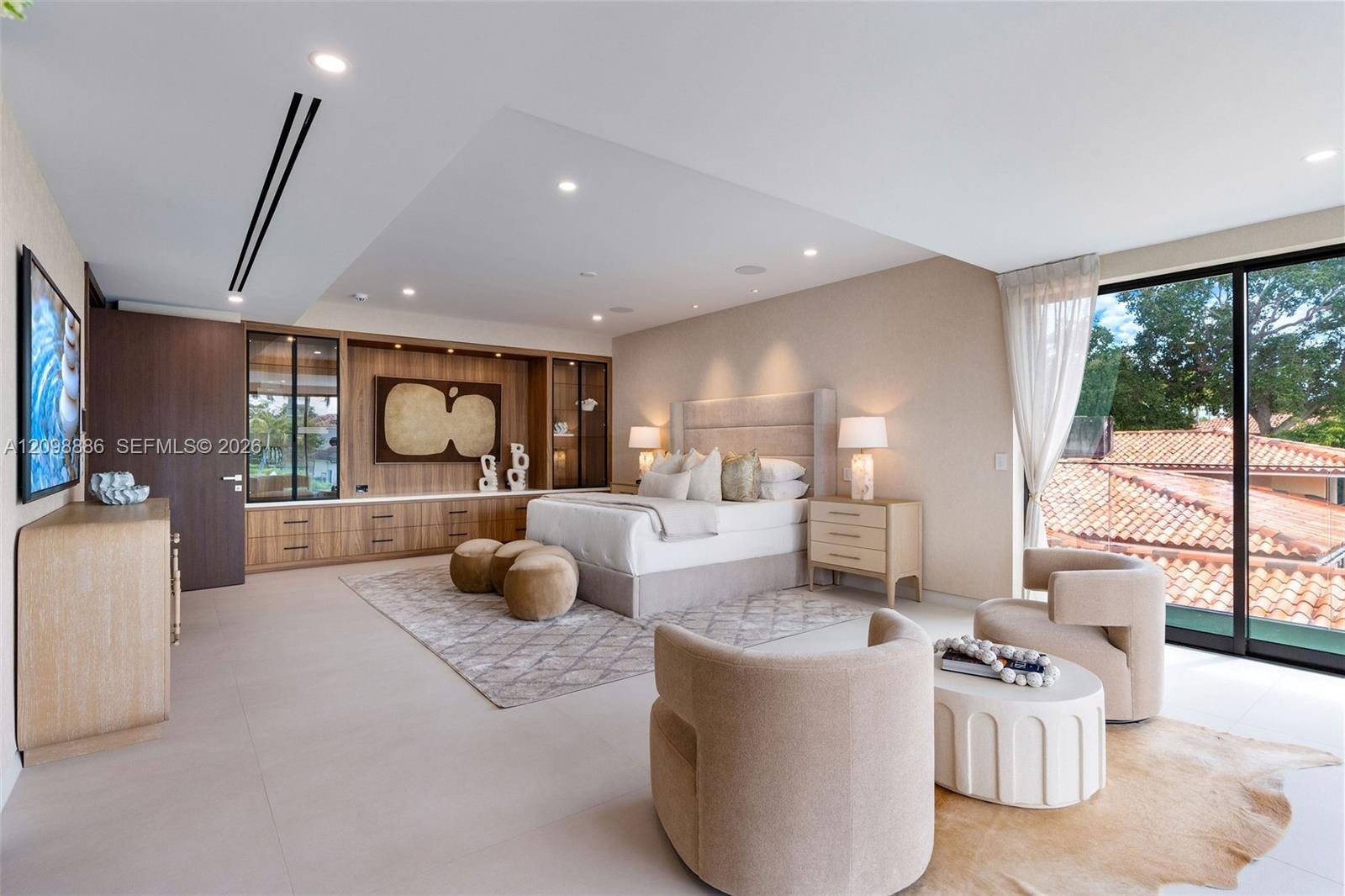 Built-in wood-finish cabinetry, recessed ceiling lighting, large-format tile flooring, and floor-to-ceiling glass sliding doors