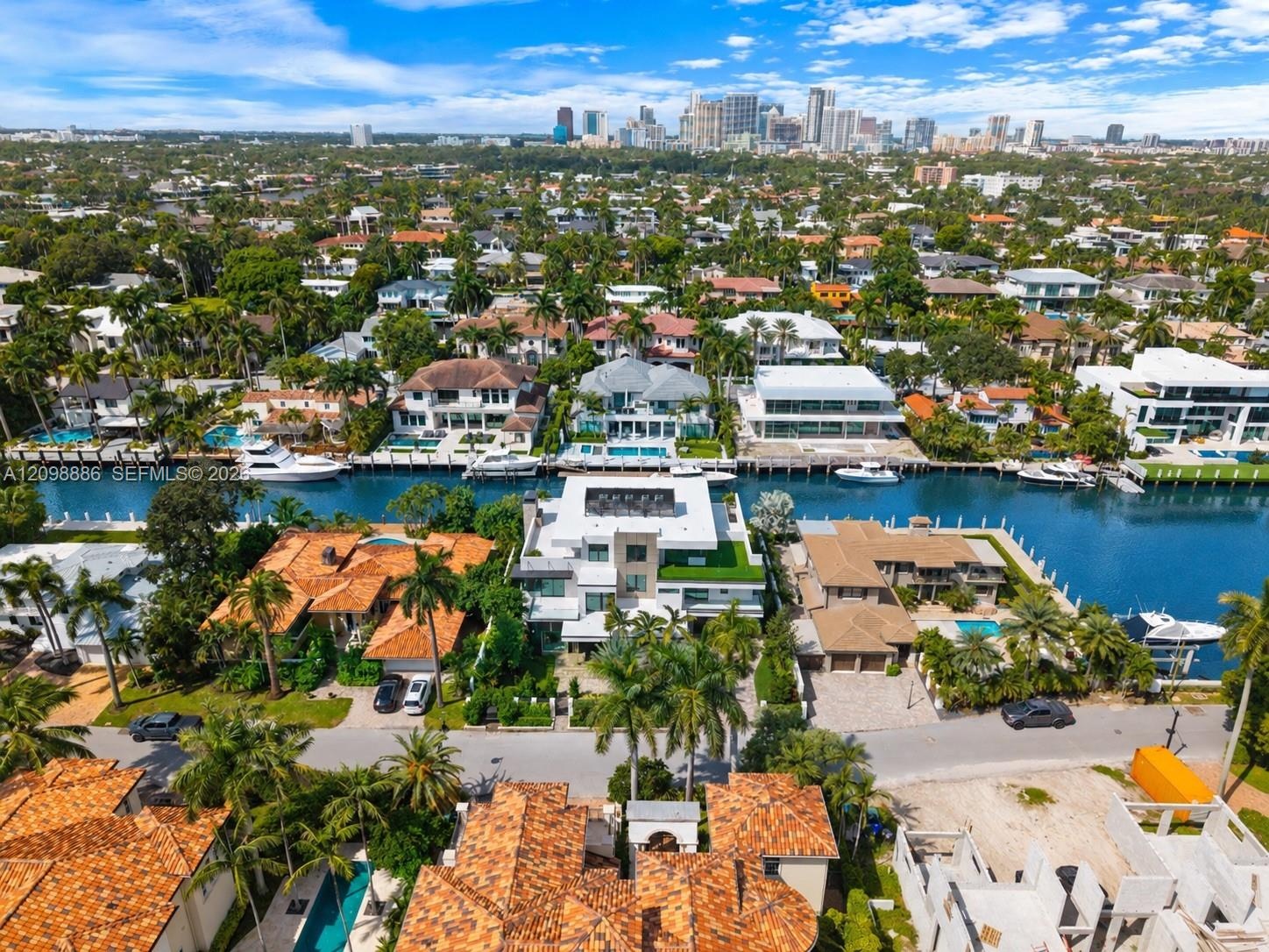 Aerial perspective of waterfront property featuring deep-water canal access, private boat dockage, and a multi-level structure with roof terrace and f