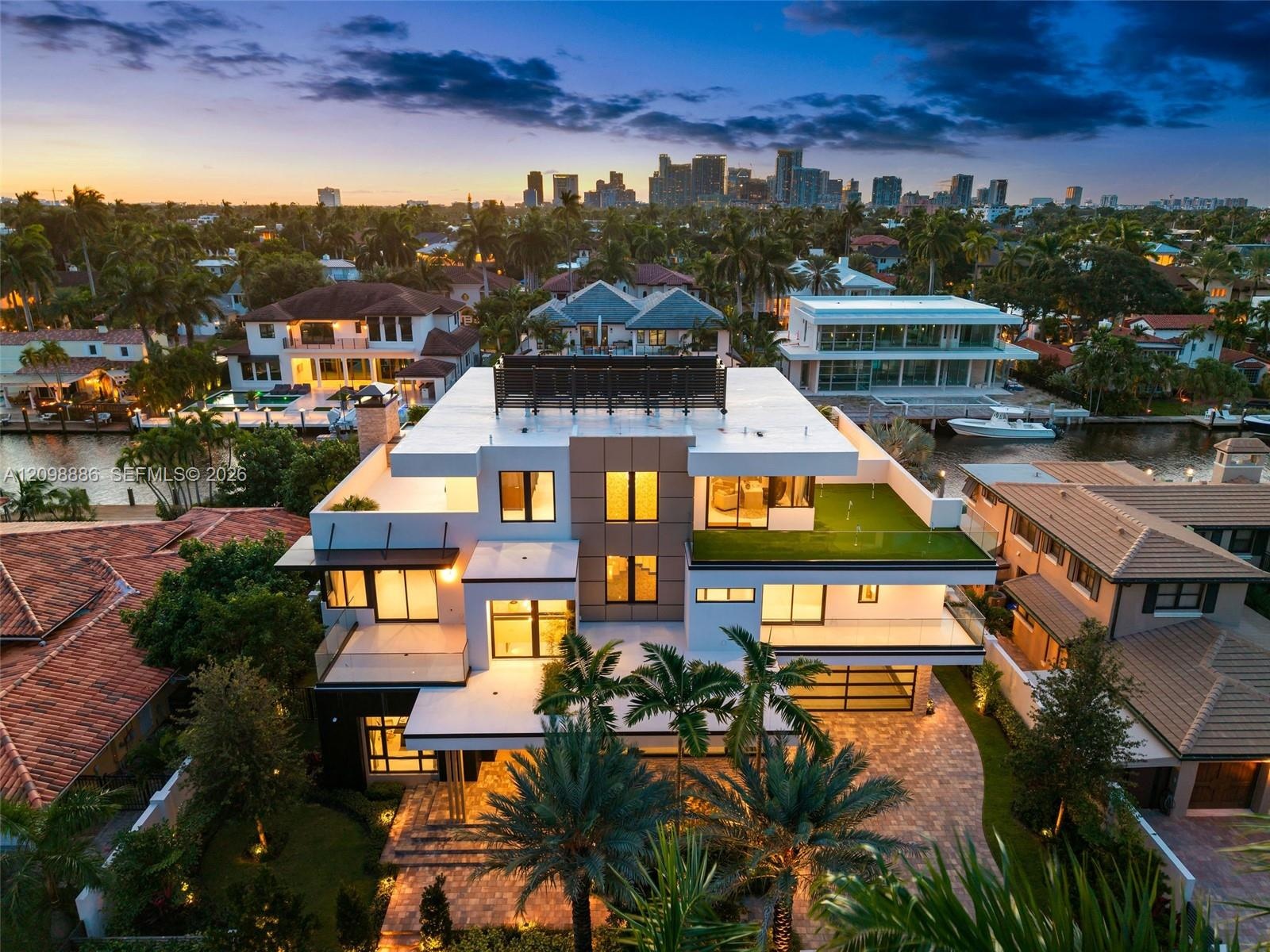 Multi-level contemporary residence featuring a rooftop terrace, tiered balconies with glass railings, composite stone exterior detailing, integrated r