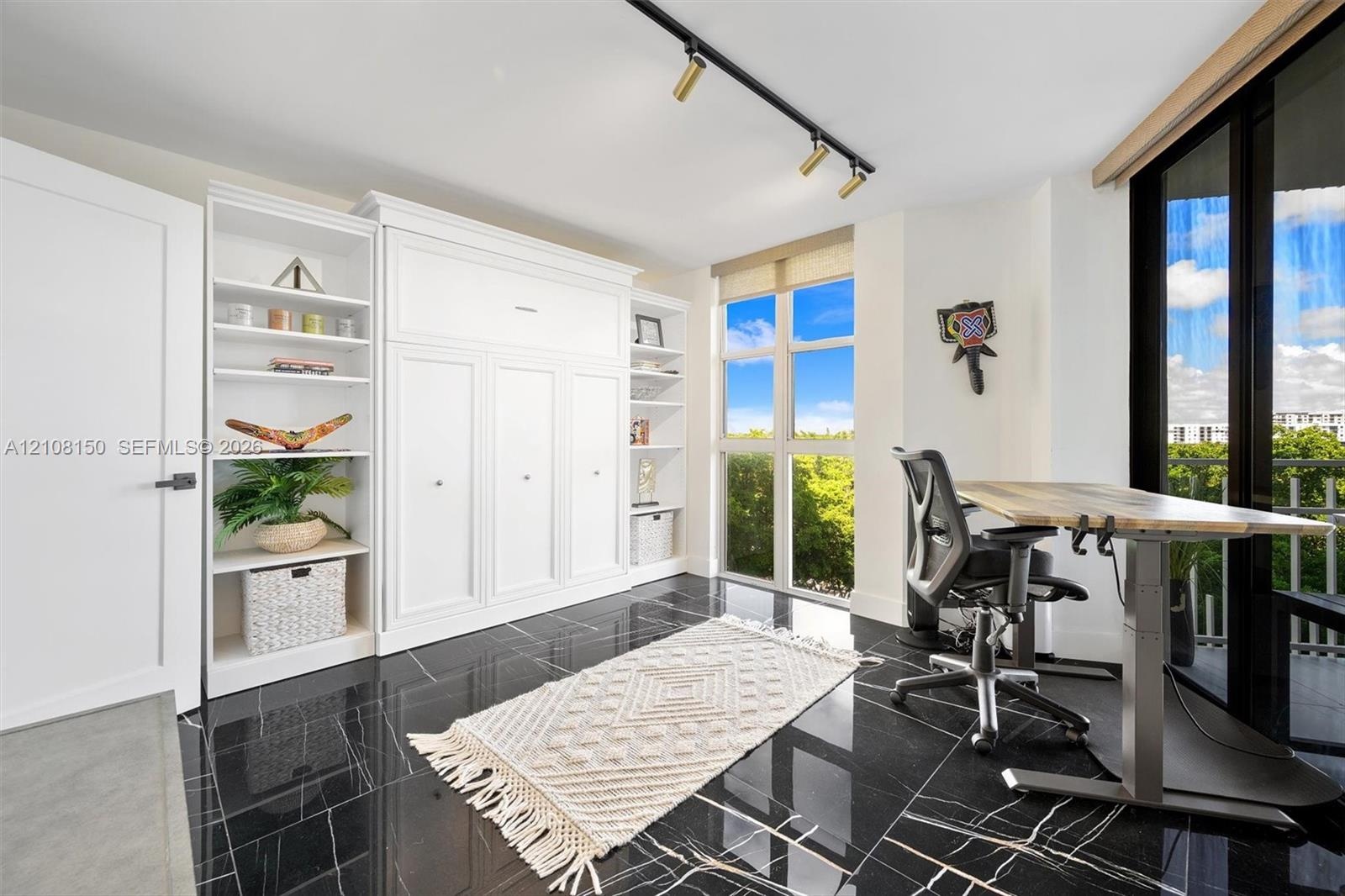 Polished black tile flooring, floor-to-ceiling windows, built-in cabinetry with integrated shelving, and adjustable track lighting