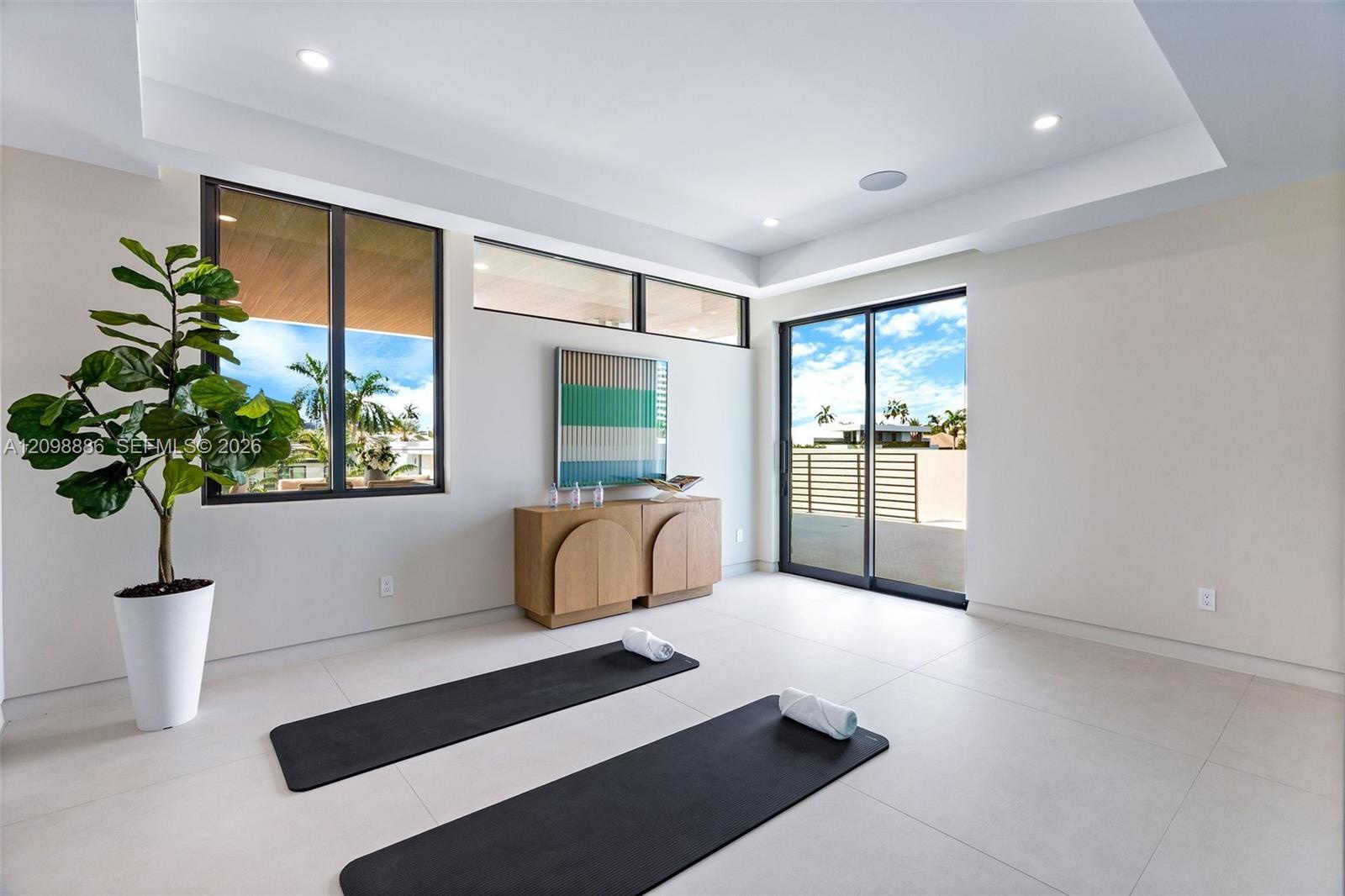 Interior space featuring large-format tile flooring, recessed ceiling lighting, clerestory windows, and glass sliding doors providing exterior exposur