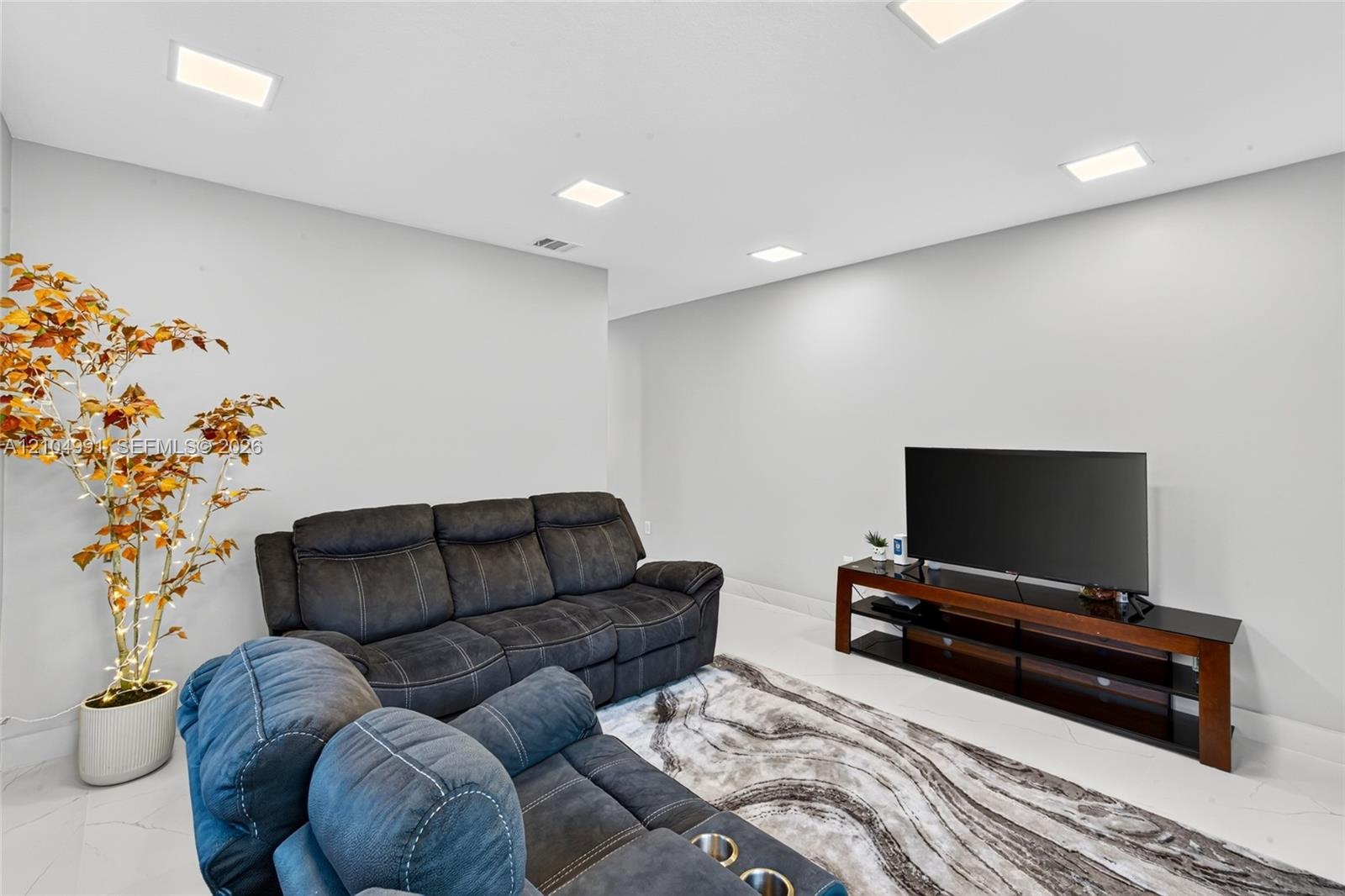 Neutral-toned interior space featuring light-colored tile flooring and recessed LED lighting