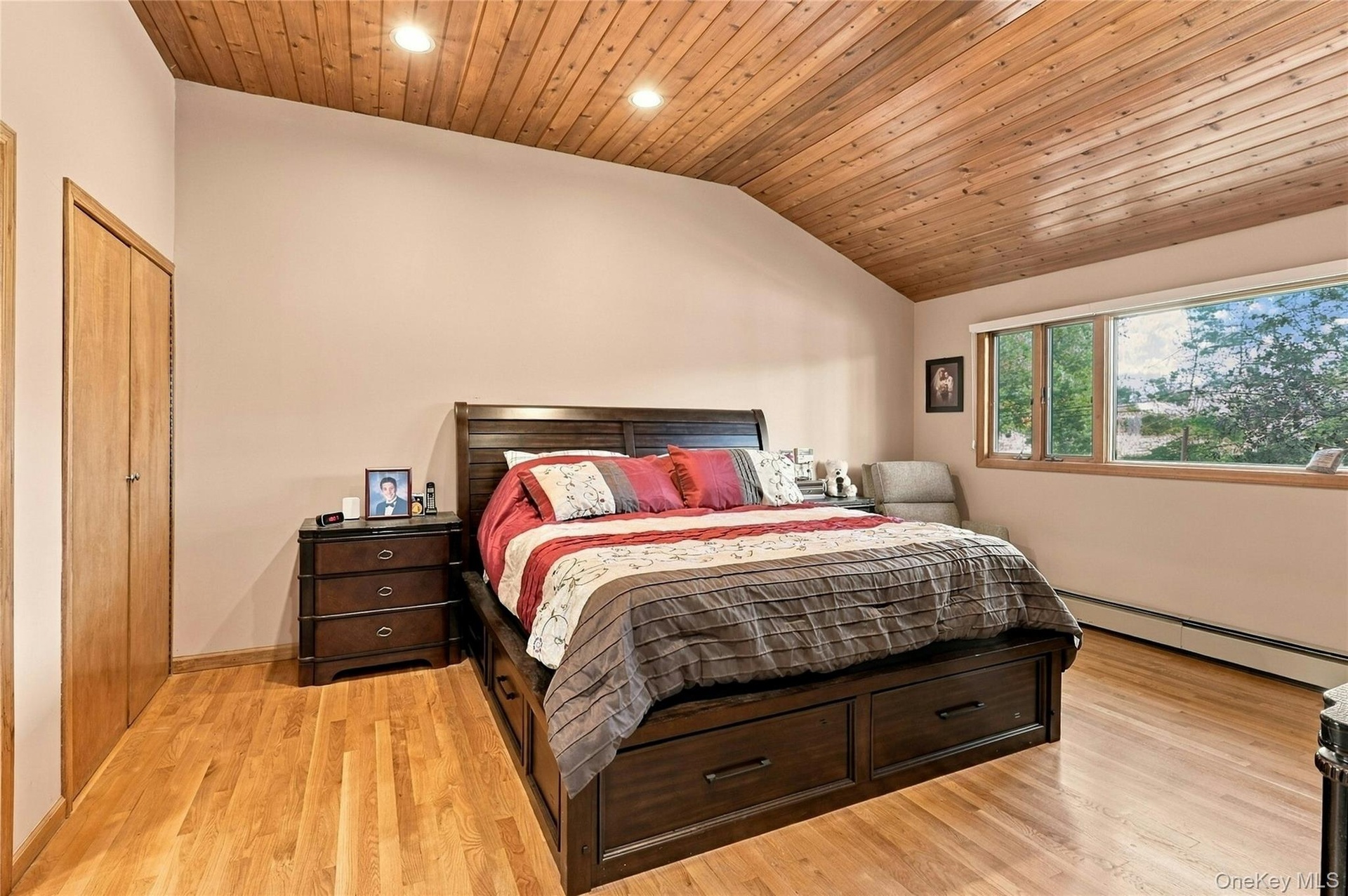 Vaulted wood-plank ceiling featuring recessed lighting, natural wood-finish flooring, and built-in closet with wood doors