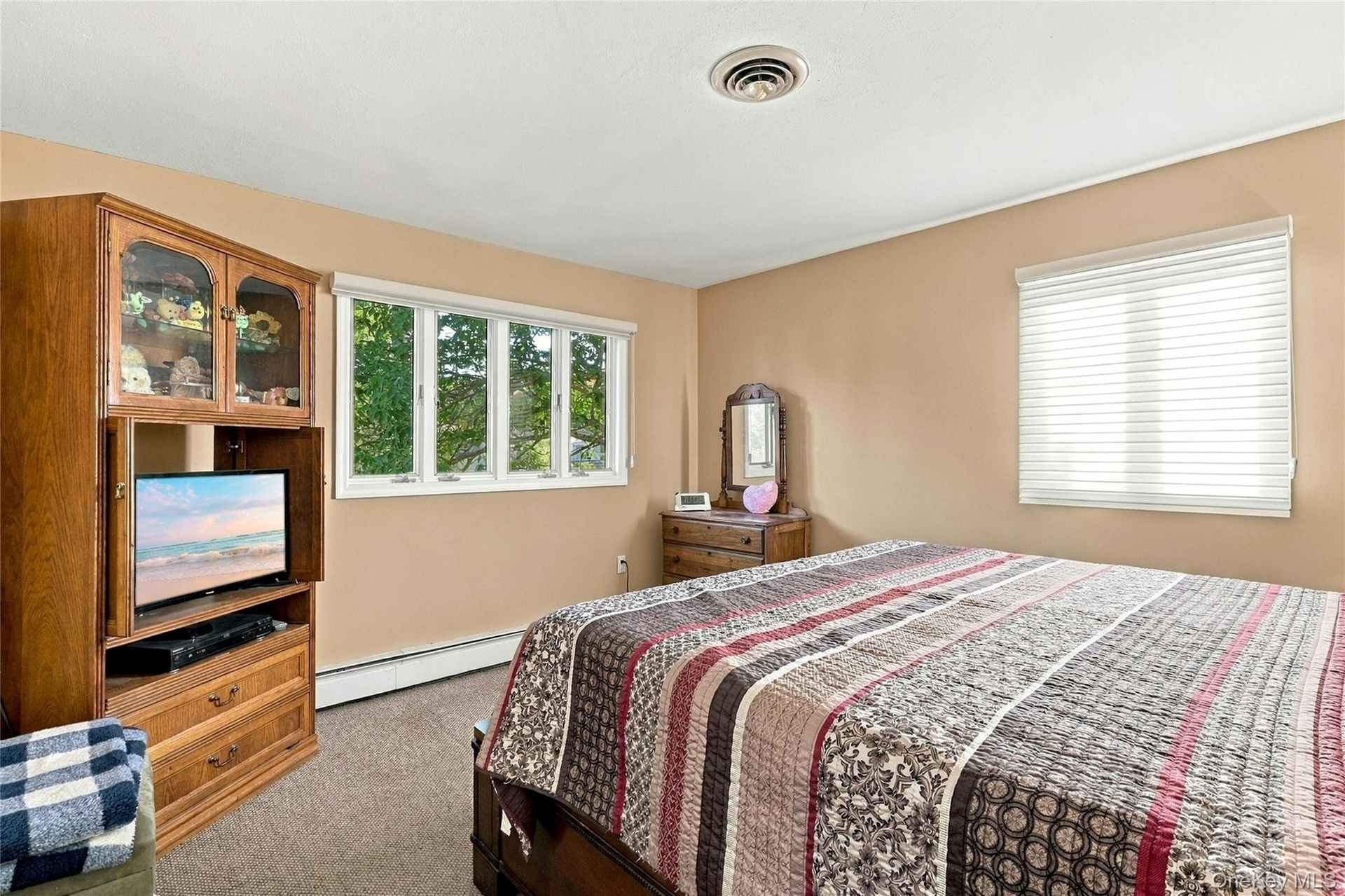 Neutral-toned interior room featuring wall-to-wall carpeting and two windows with white frames