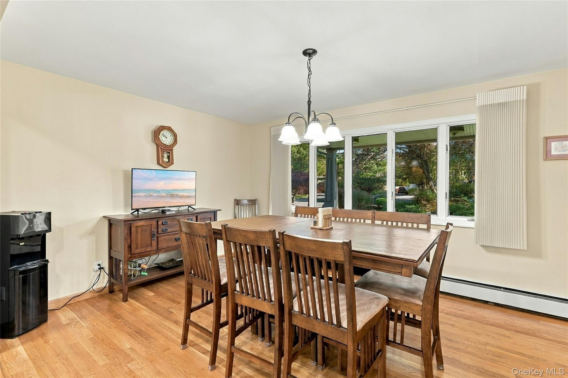 Wood-finish flooring, oversized multi-pane window, and four-light metal chandelier
