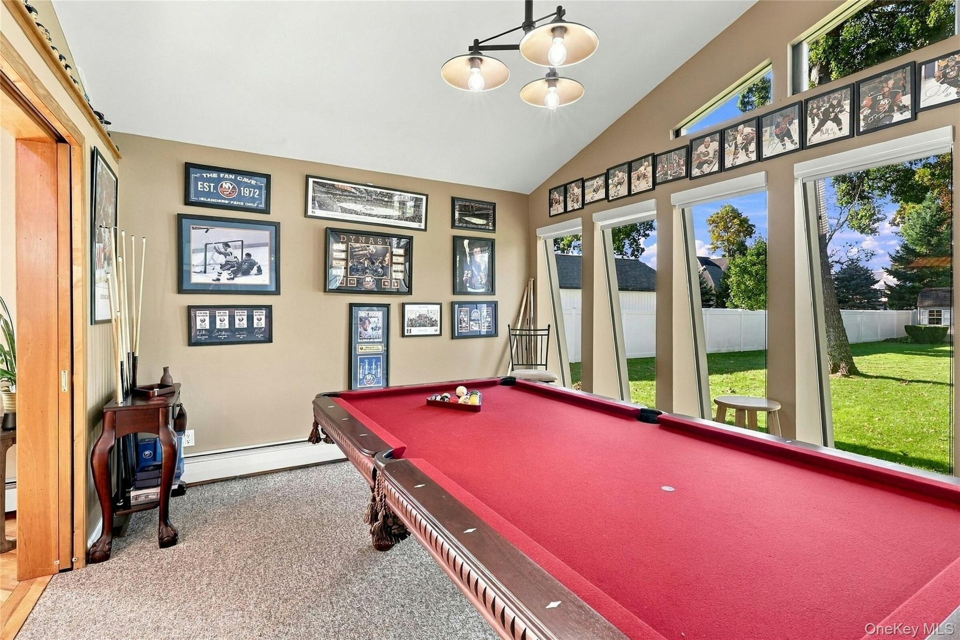 Vaulted ceiling featuring a multi-bulb pendant light, expansive floor-to-ceiling windows, and wall-to-wall carpeting