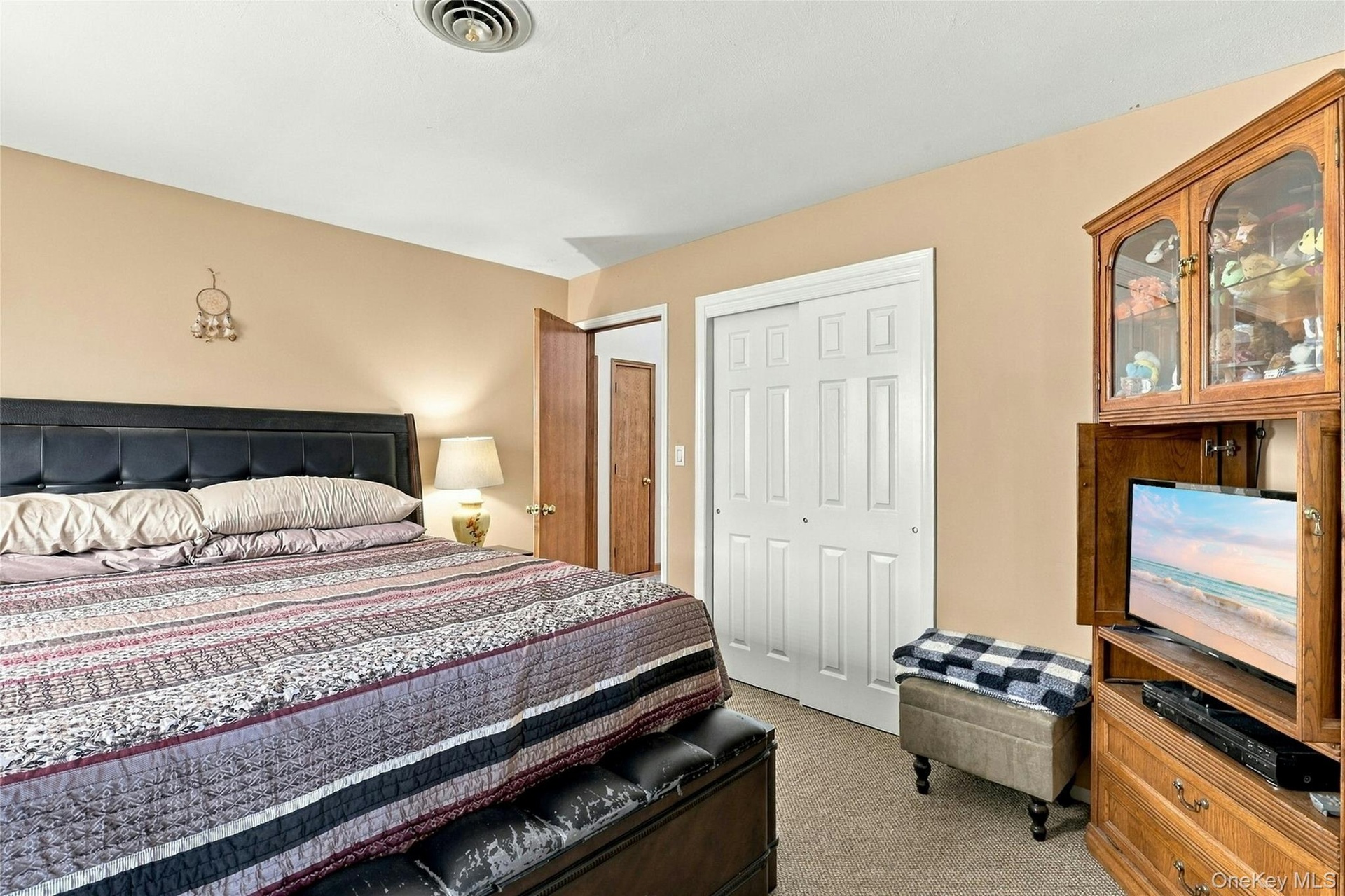 Neutral wall tones, carpeted flooring, and double-panel sliding closet doors with white trim
