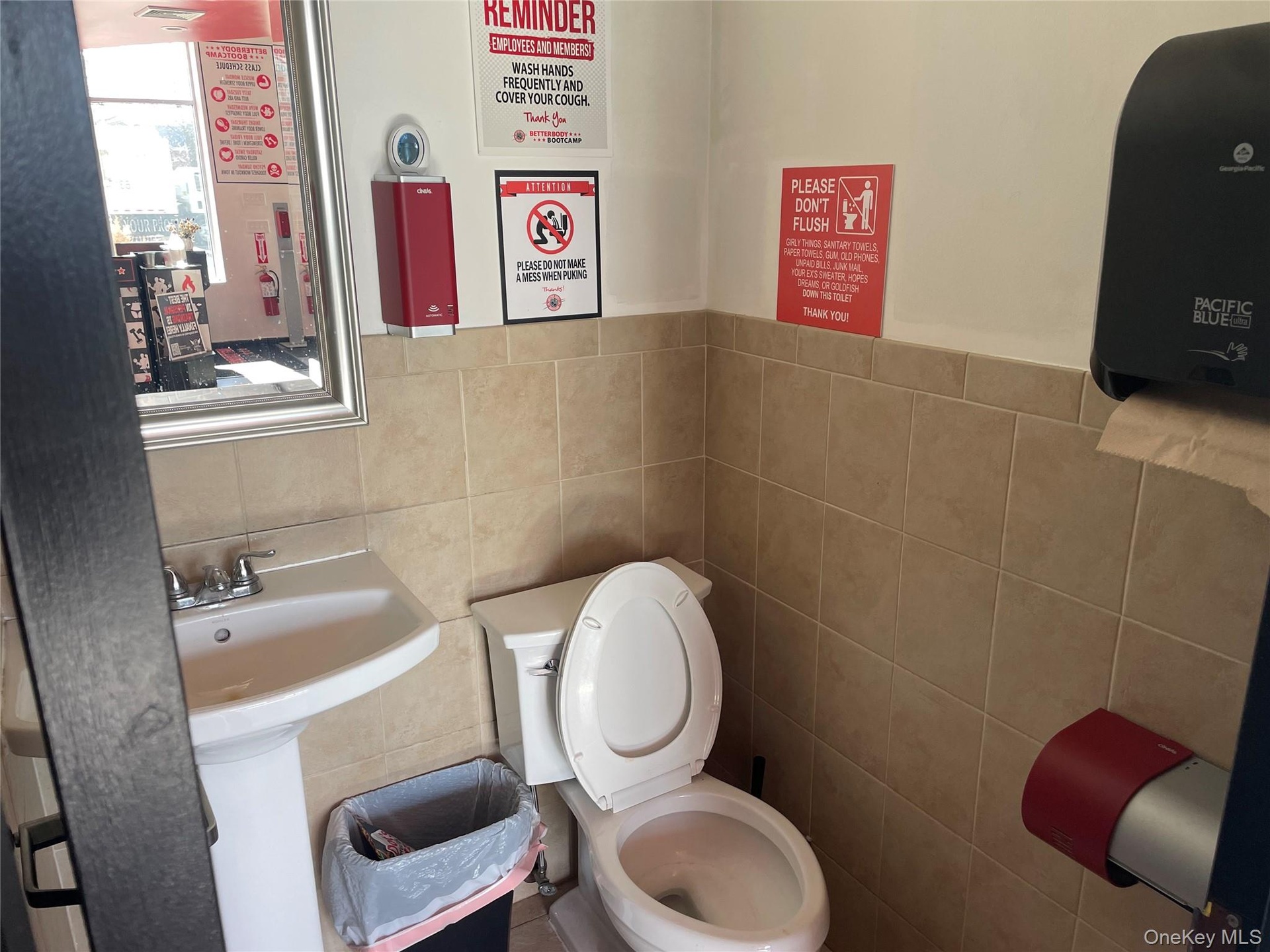 Bathroom featuring toilet and tile walls