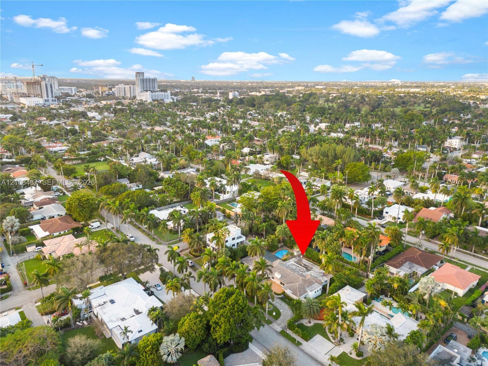 Aerial perspective showcasing a residential property featuring a private swimming pool, mature perimeter landscaping, and a paved driveway