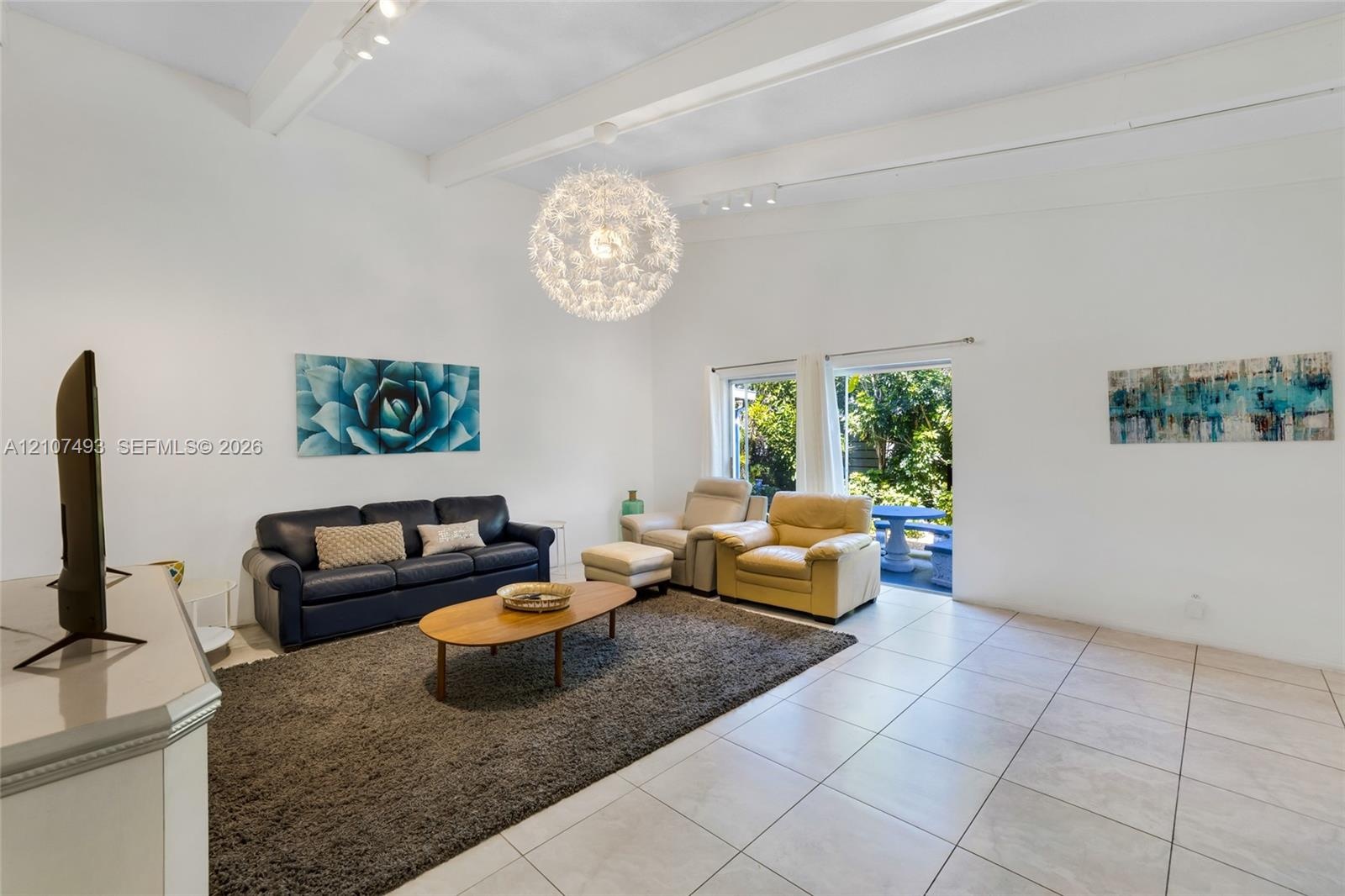 Vaulted ceilings with exposed structural beams, tile flooring, and a large spherical pendant light fixture