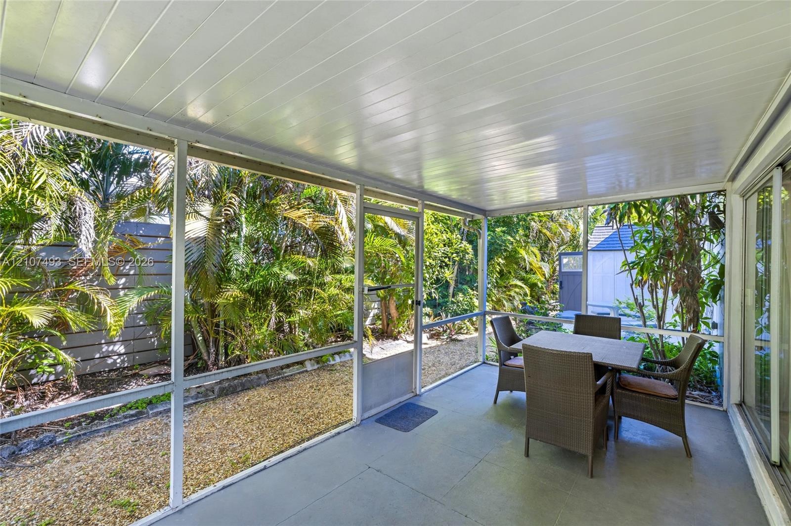 Screened-in porch featuring a painted concrete floor, a beadboard ceiling, and full-height mesh screening