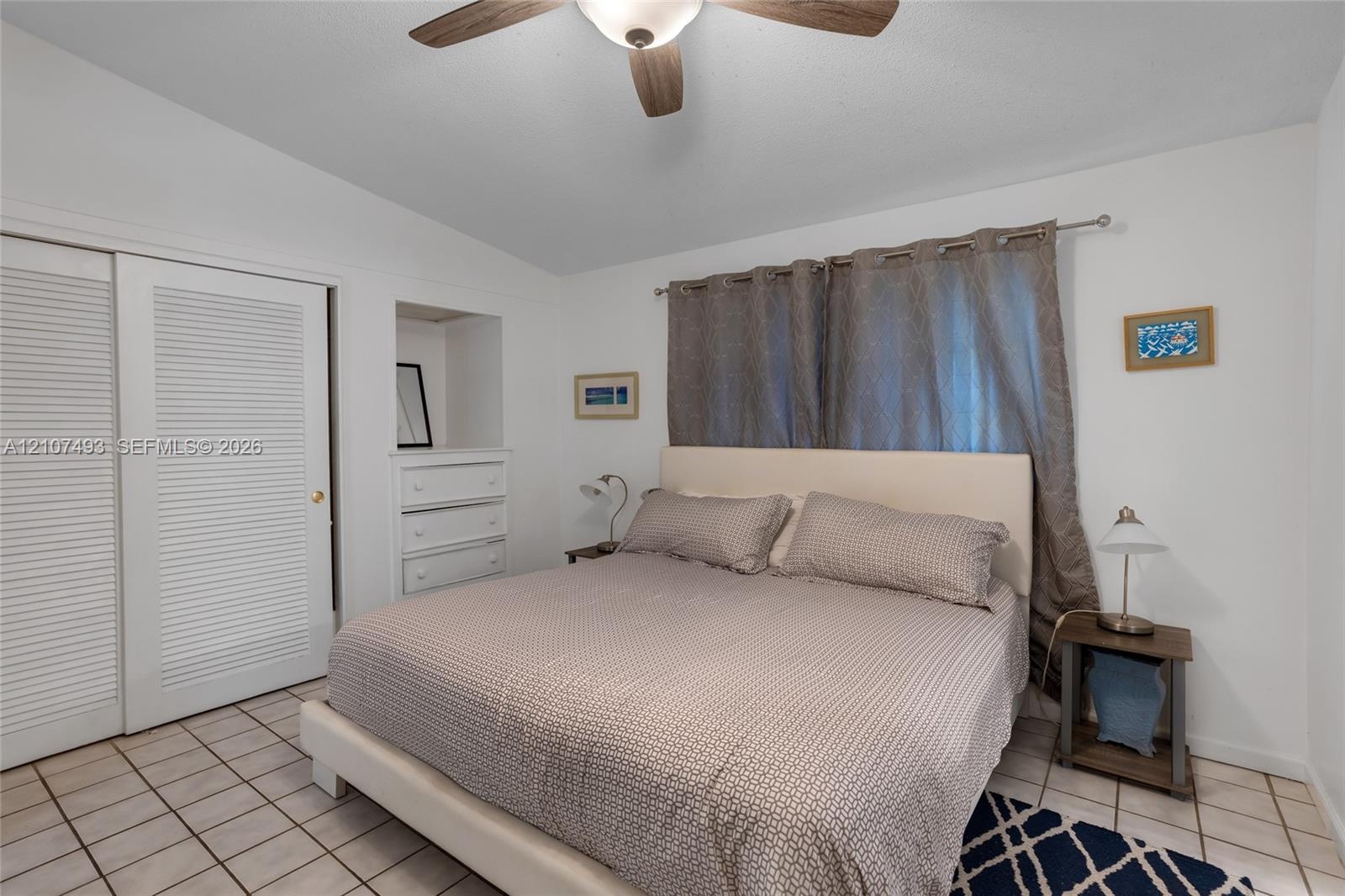 Ceramic tile flooring, built-in recessed cabinetry, and ceiling fan with integrated lighting