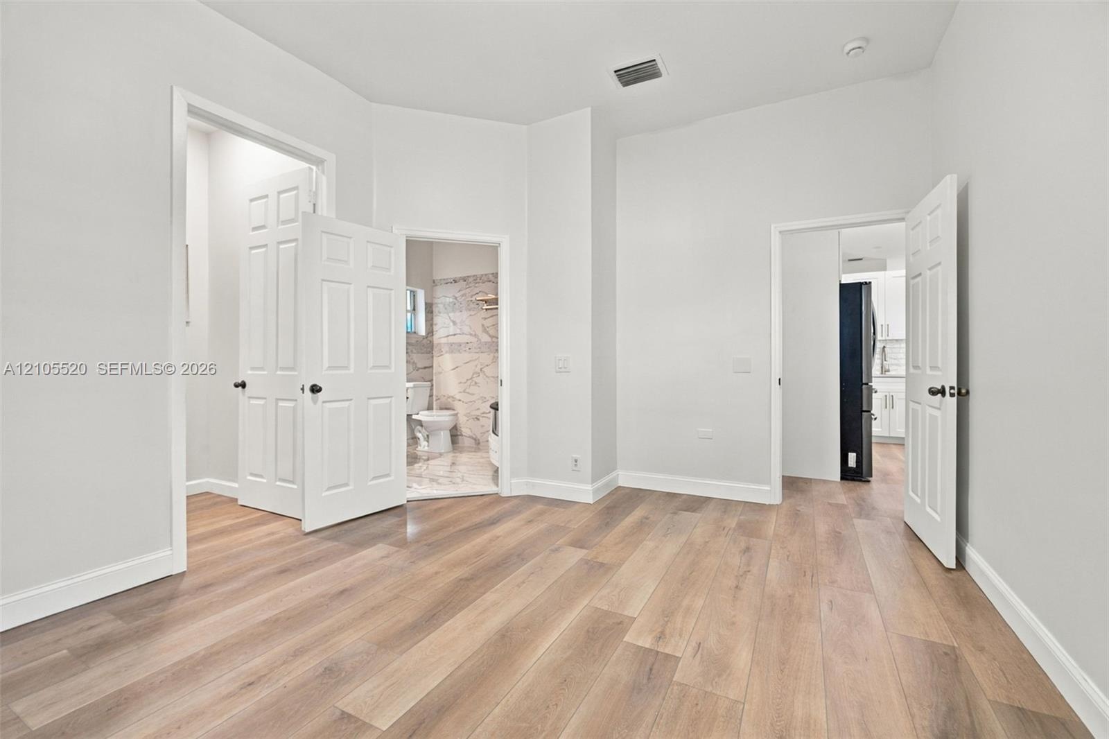 Interior space featuring wood-finish flooring, high ceilings, and multi-panel interior doors