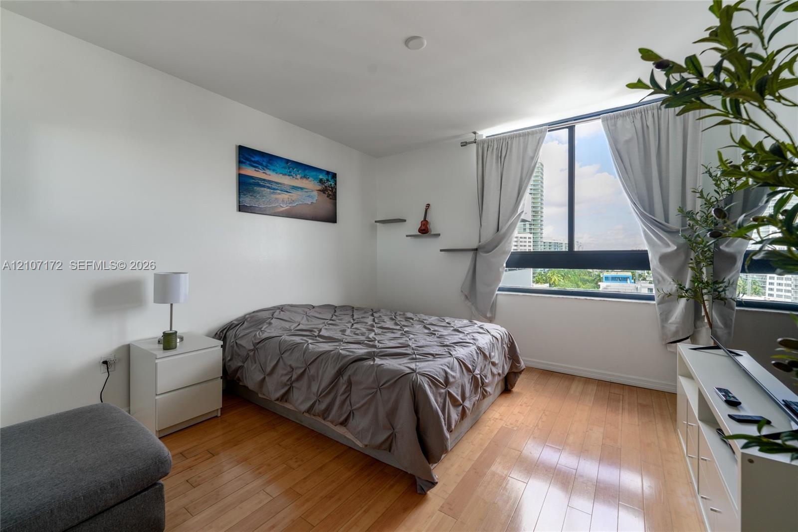Floor-to-ceiling windows, wood-finish flooring, and wall-mounted shelving