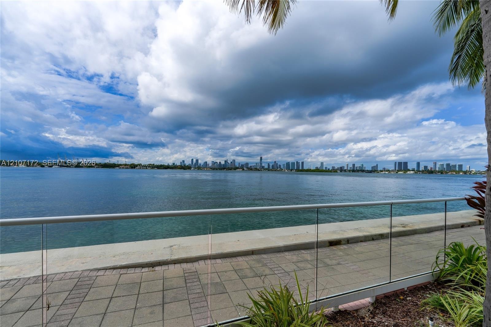 Aerial perspective featuring a sprawling coastal waterway, islands with residential landscaping, and a distant metropolitan skyline