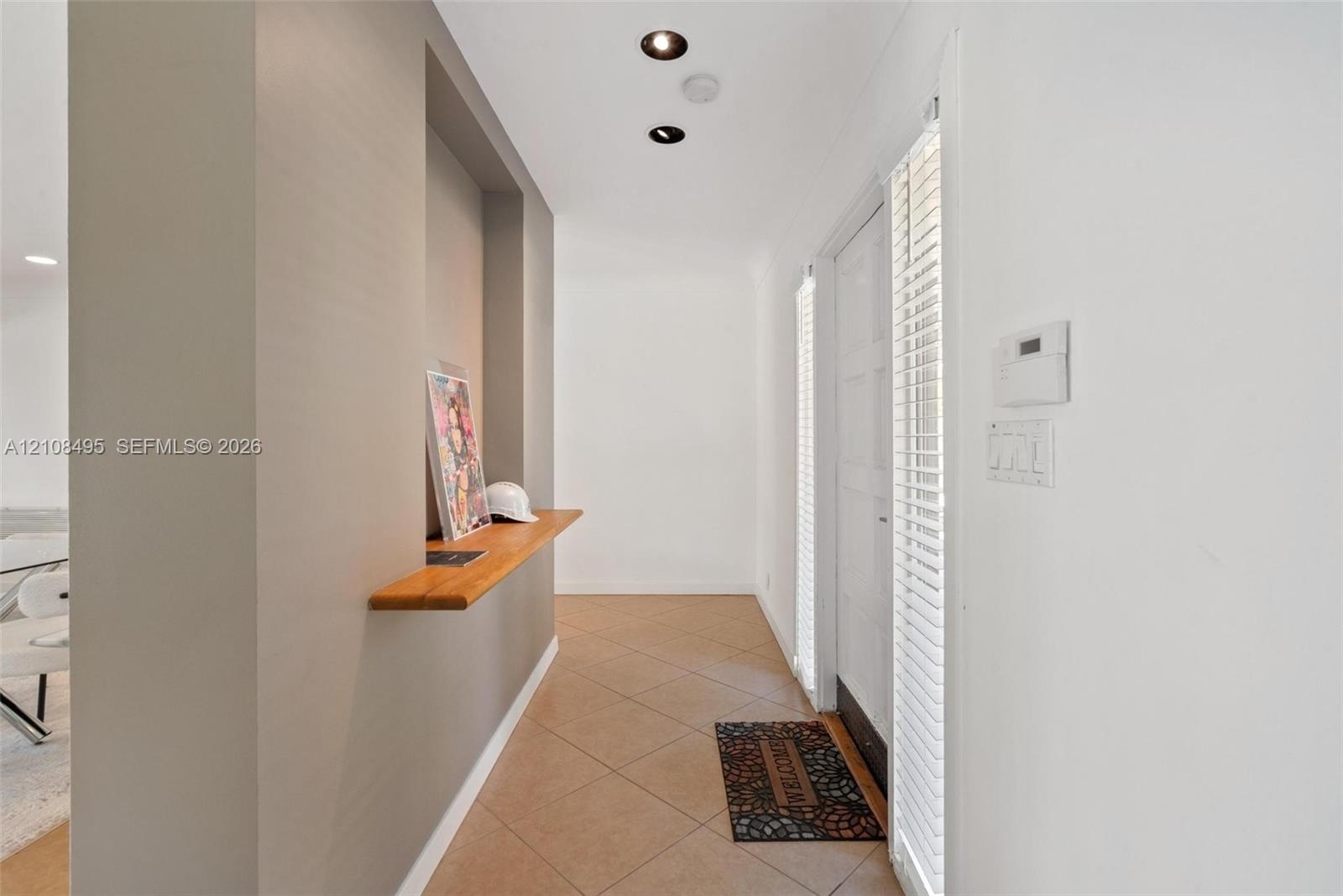 Modern architectural exterior featuring a multi-level facade, expansive floor-to-ceiling windows, integrated recessed lighting, stone-paver driveway, 