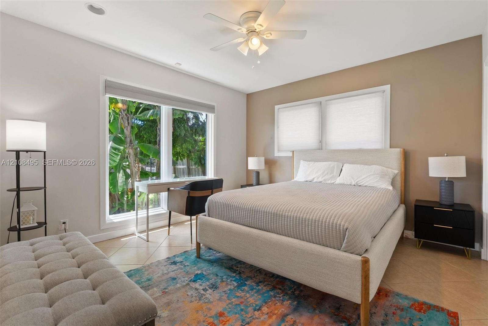Open-concept living space featuring neutral tile flooring, recessed ceiling lighting, and expansive dual sliding glass doors