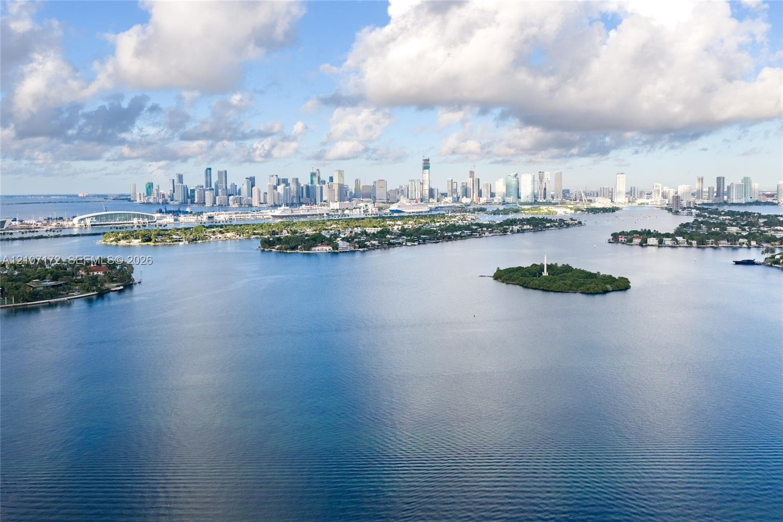 Aerial perspective showcasing a coastal metropolitan landscape, high-rise urban density, integrated athletic track facility, and proximity to shorelin