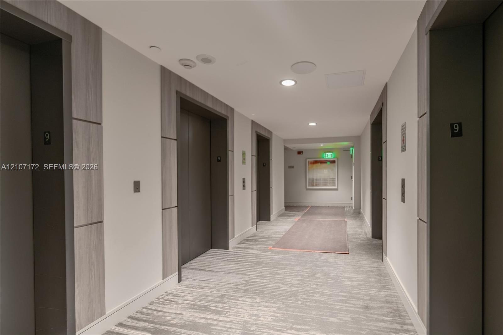 Lobby featuring polished stone flooring, recessed ceiling lighting, a curved architectural wall, and a built-in reception desk with illuminated stone-