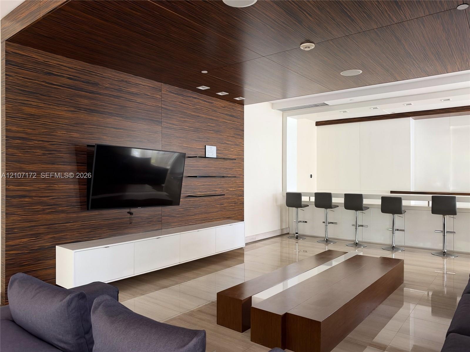 Floor-to-ceiling windows, polished stone flooring, and multiple glass-paned doors featuring metal frames