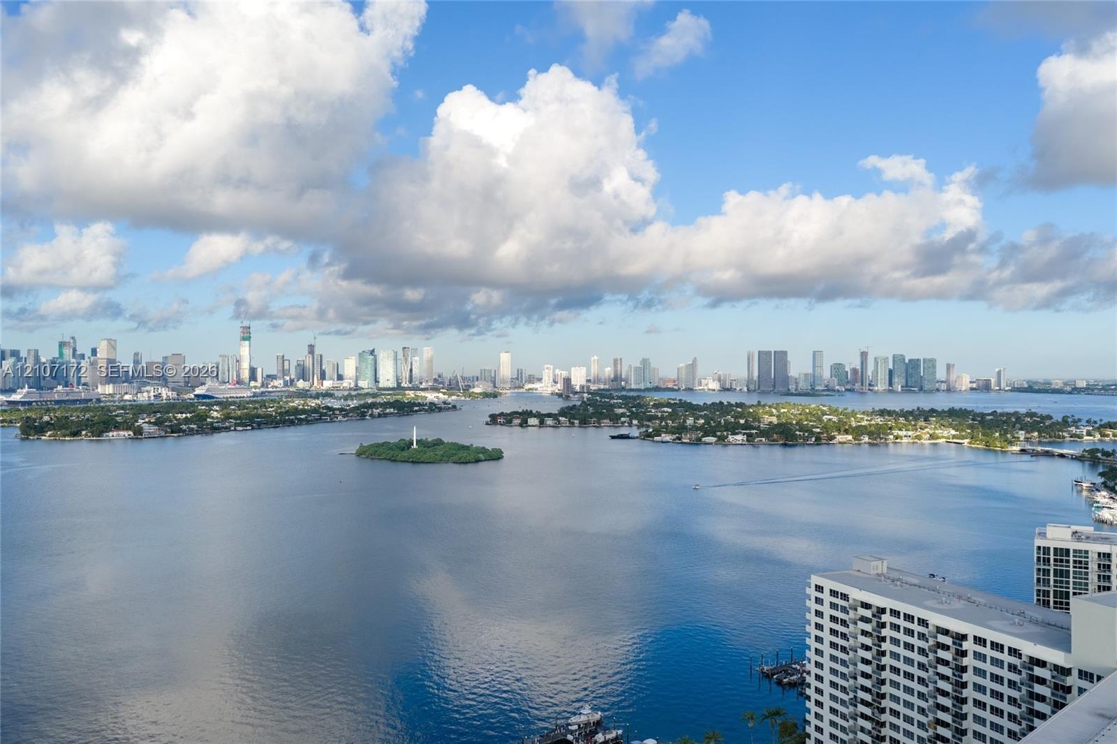 Aerial perspective featuring an expansive cityscape, horizon-spanning skyline, and distant coastal waters under a vast sky
