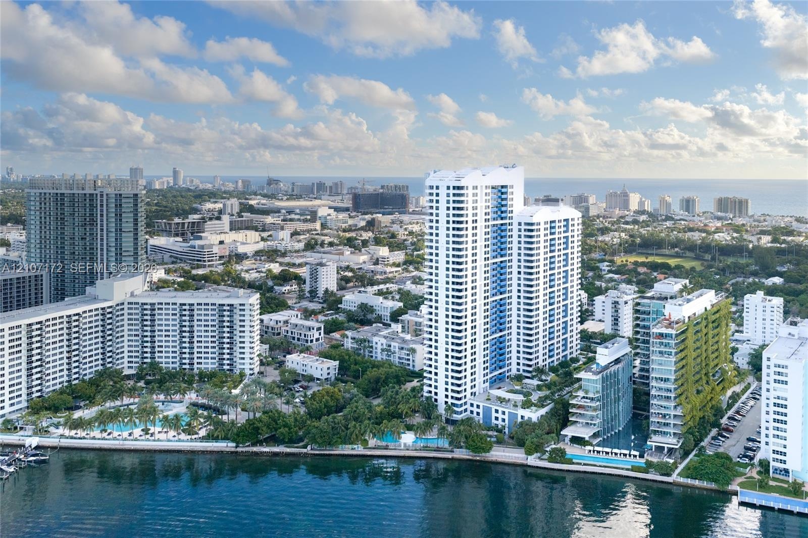 Aerial perspective featuring a metropolitan skyline, deep water bay, and waterfront island landscape