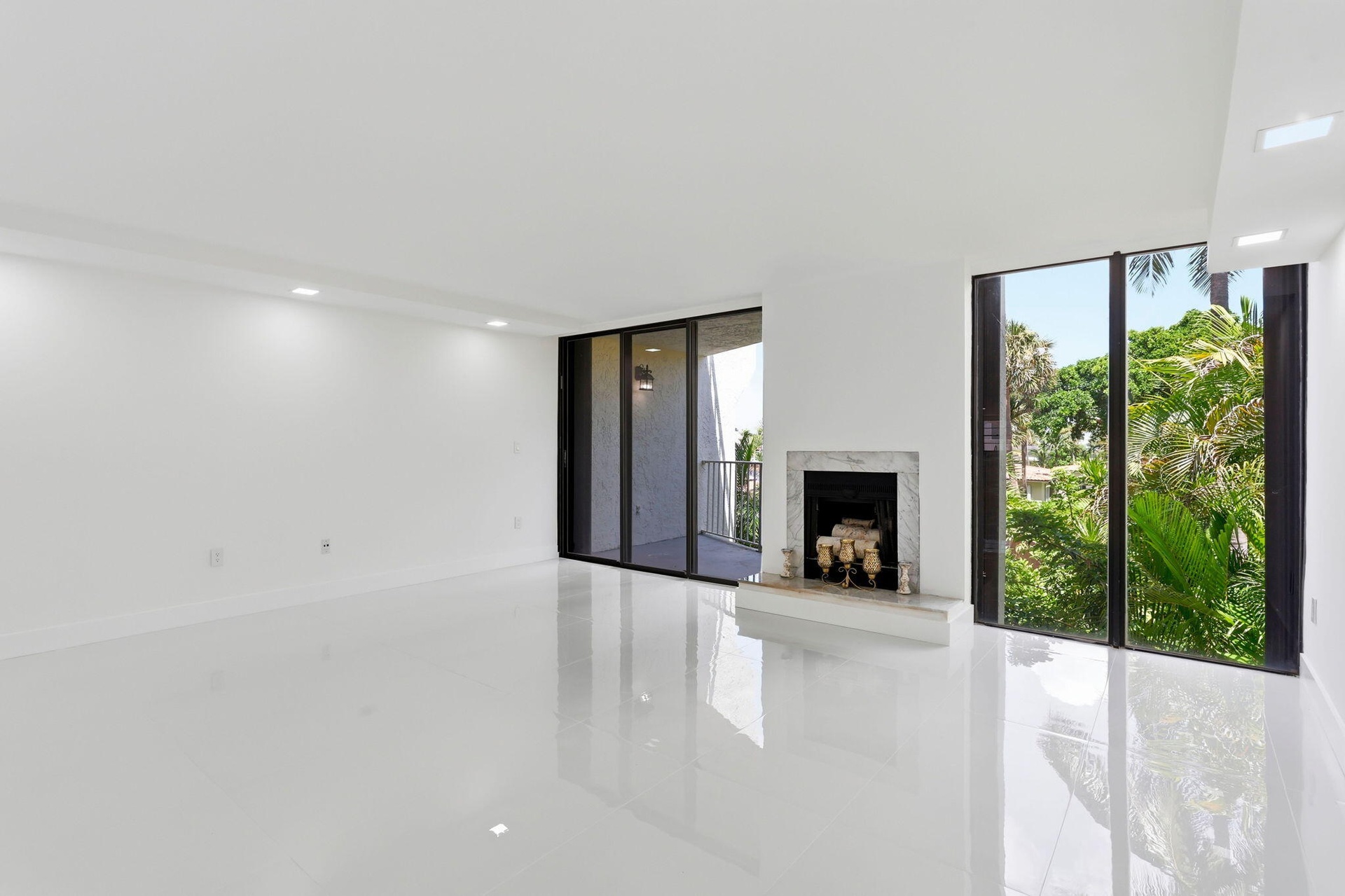 Spacious interior featuring white tile flooring, recessed lighting, and a white marble fireplace