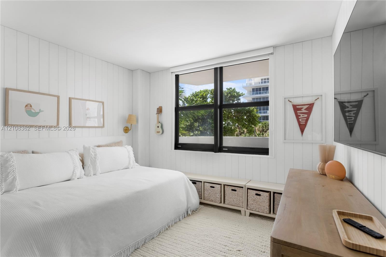 Vertical shiplap wall paneling, built-in low-profile cabinetry, and black-framed windows