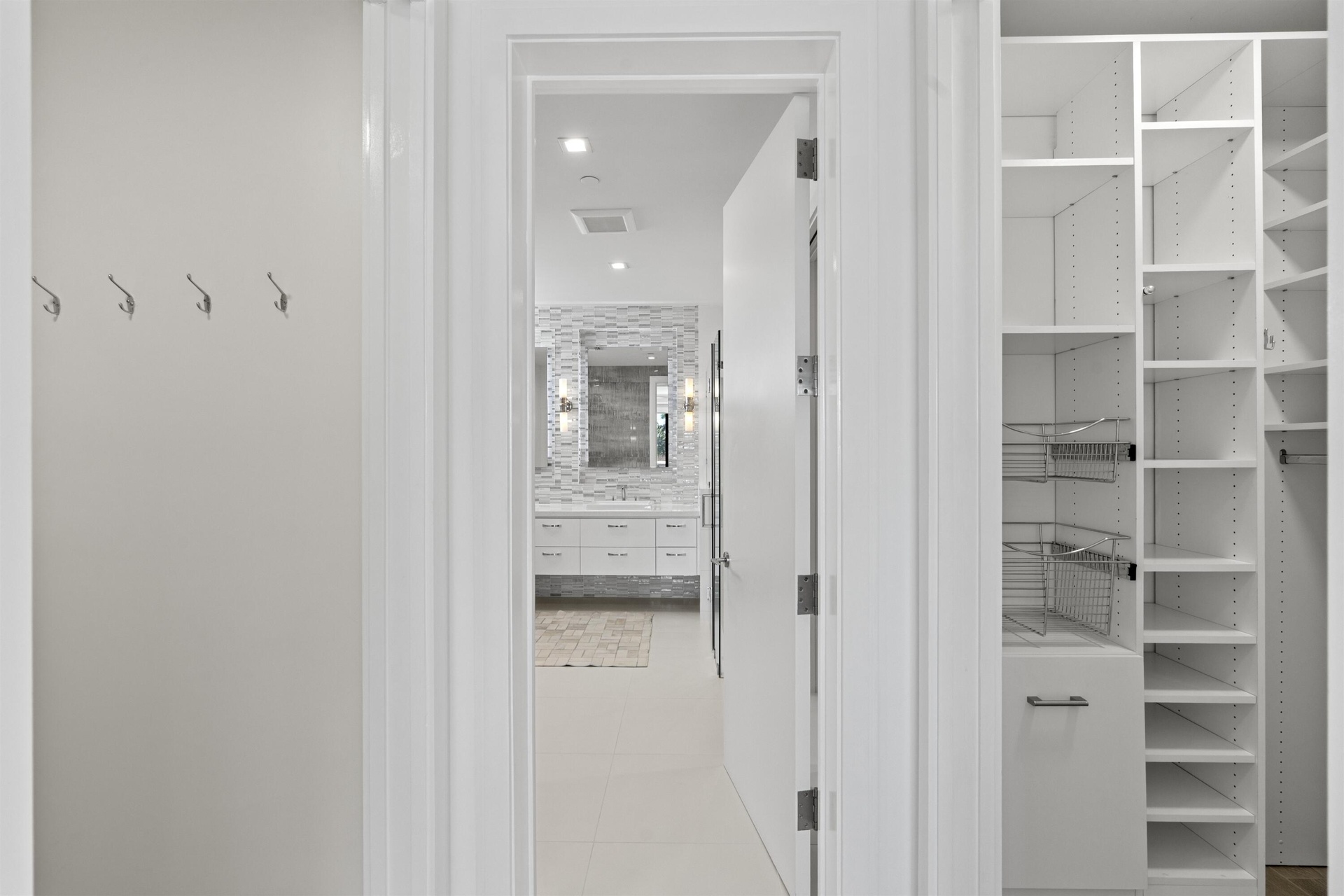 Custom fitted his and hers closets in Primary Suite leading to bathroom