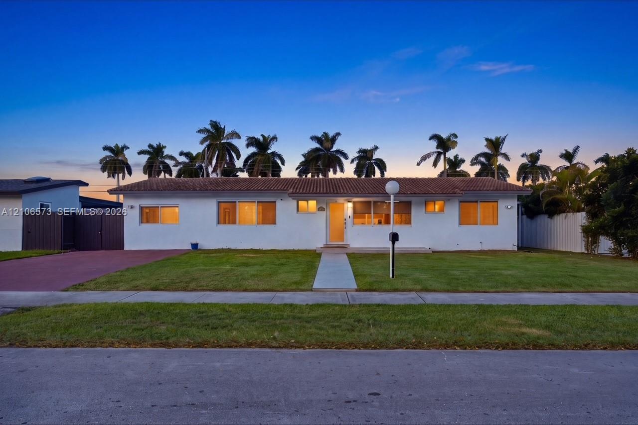 Single-story residence featuring a smooth stucco exterior, a tiled roof, a concrete walkway, and a paved driveway