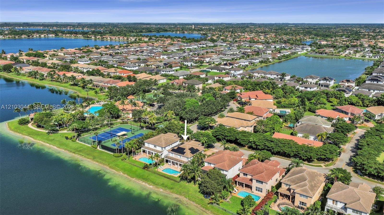 Waterfront property featuring a private swimming pool, tile roof, and solar panels