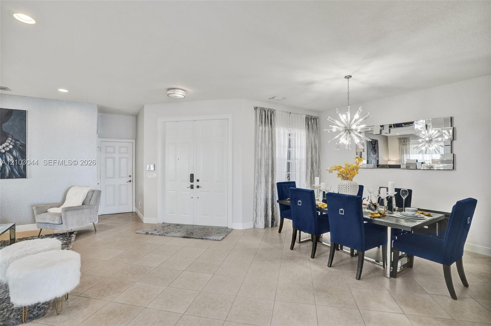 Open-concept space featuring neutral large-format tile flooring, recessed ceiling lighting, a contemporary multi-point starburst chandelier, and doubl