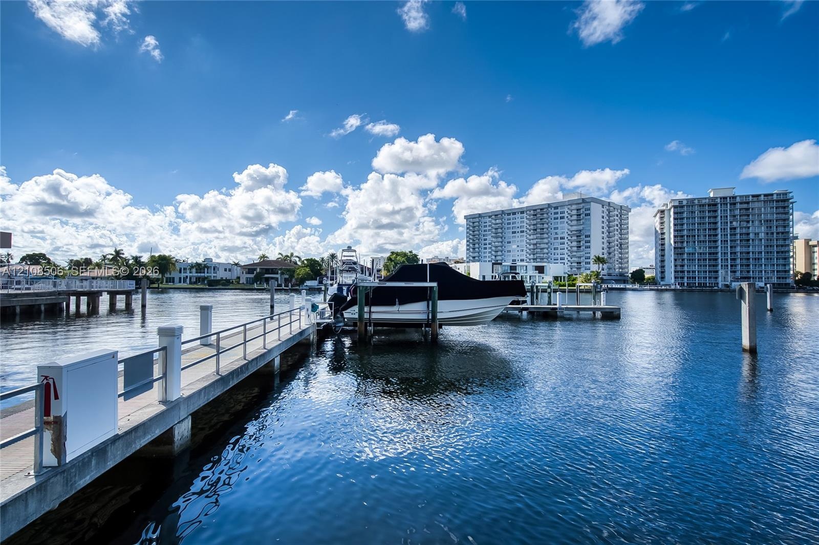 Waterfront location featuring a concrete dock, integrated boat lift, and metal railing
