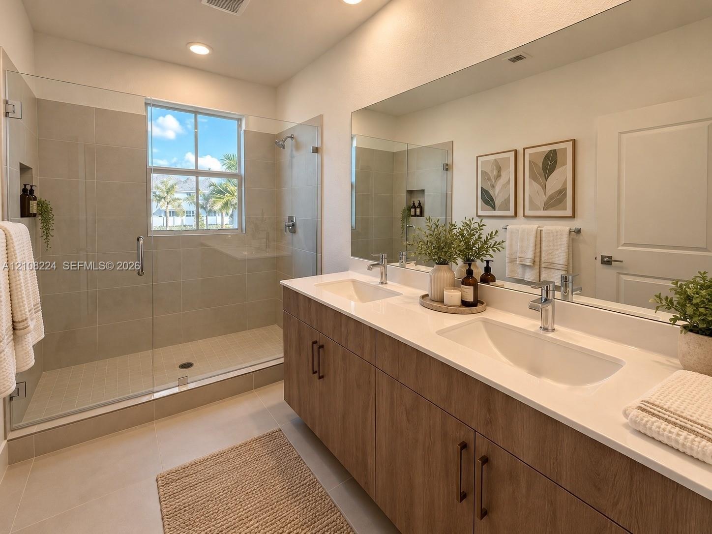 Double vanity with wood-finish cabinetry, quartz countertops, undermount sinks, full-width wall mirror, and a walk-in shower with floor-to-ceiling til