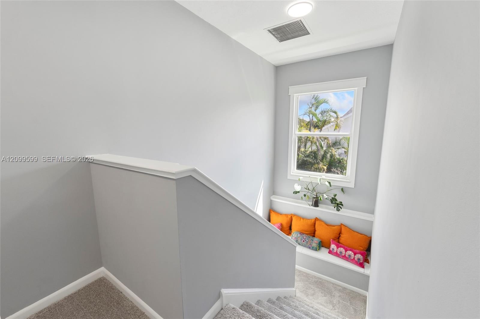 Neutral-toned interior featuring carpeting, a built-in bench seat with a display ledge, and a single-hung window with casing