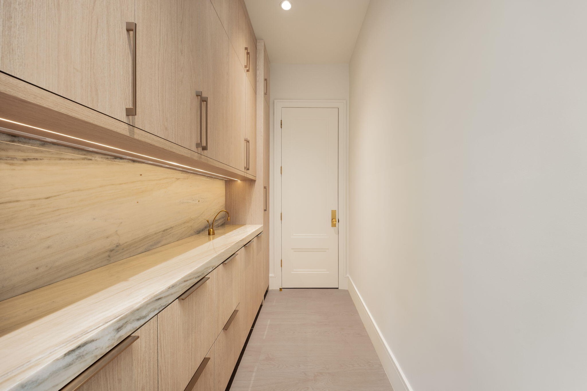 pantry floor to ceiling cabinetry , marble counter & backsplash and instahot faucet. ac closet at end of room