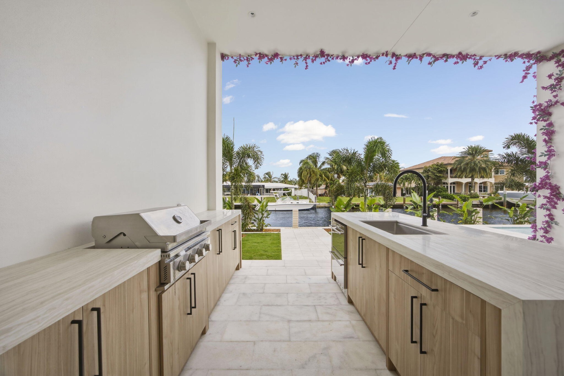 Outdoor cabinetry with Neolith Countertops and waterfall gas grill, fridge