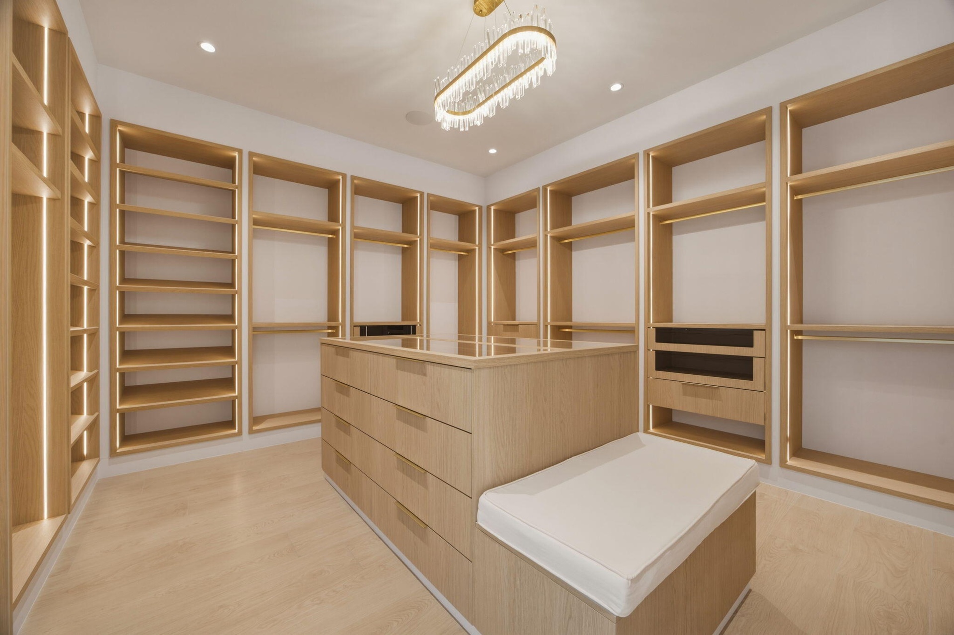 fully built out custom closet with storage bench