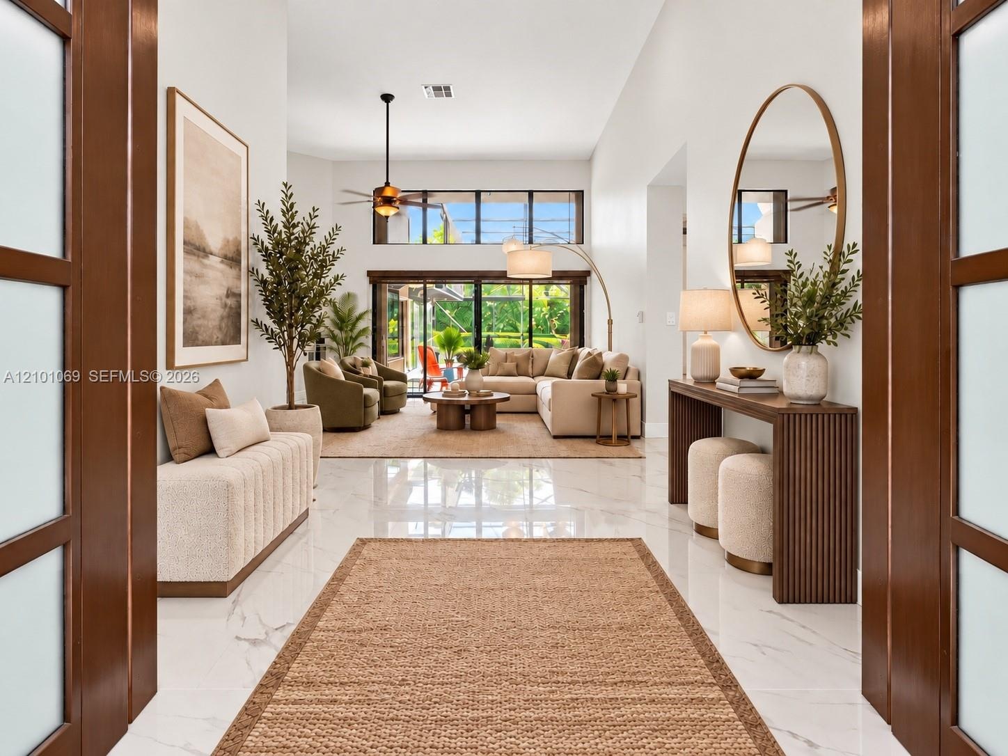 Impact front doors open to living room and dining room. virtually staged