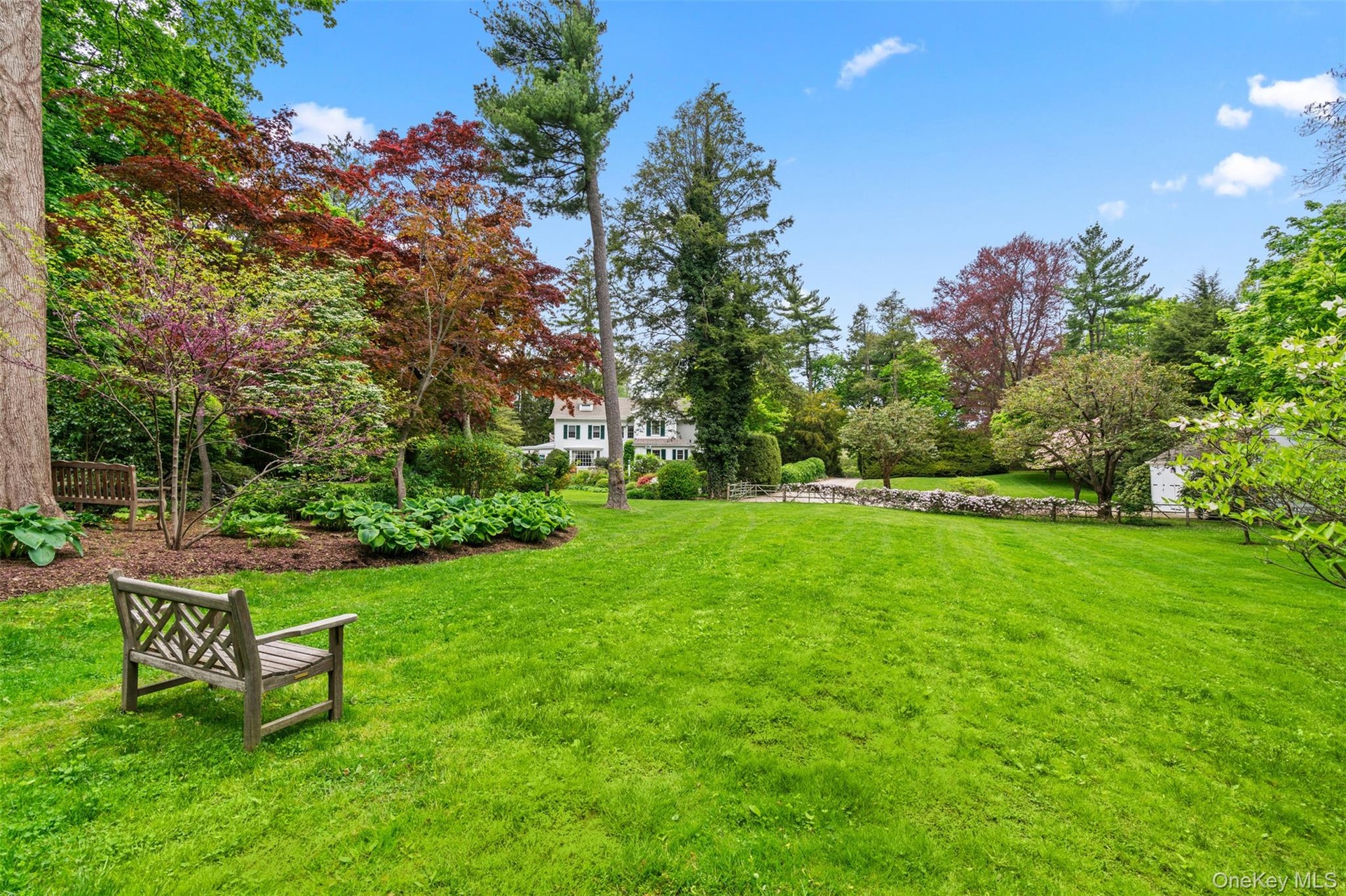 Two park like acres of level lawn and gardens