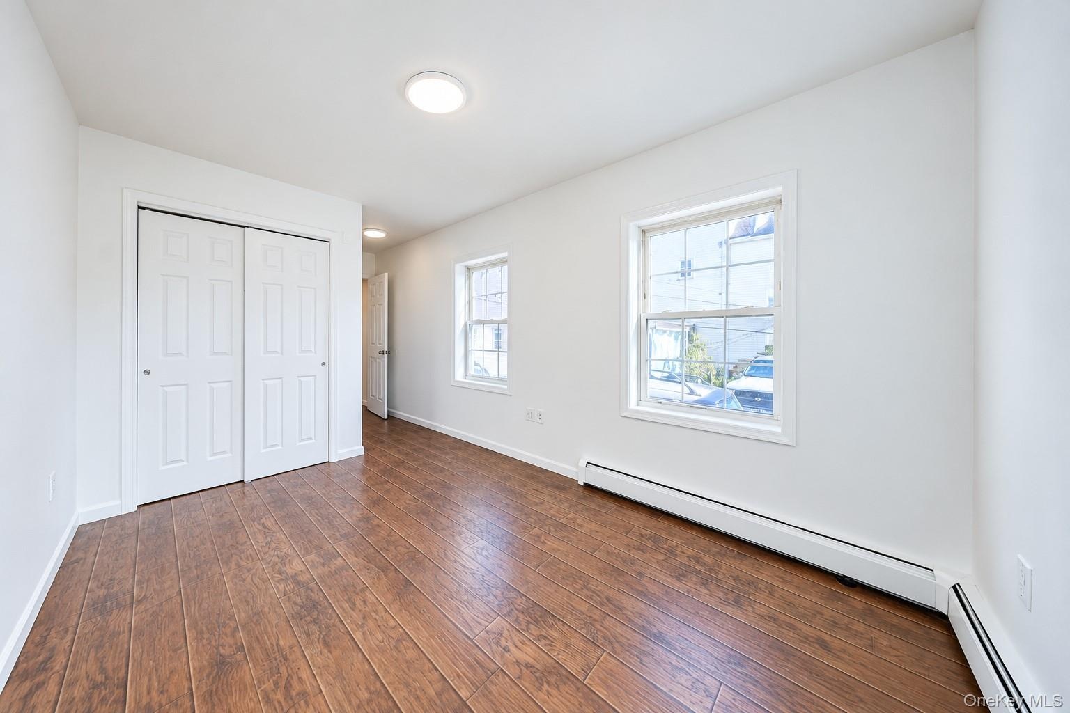 Room featuring wood-finish flooring, dual-pane windows with muntin bars, and a double-door closet