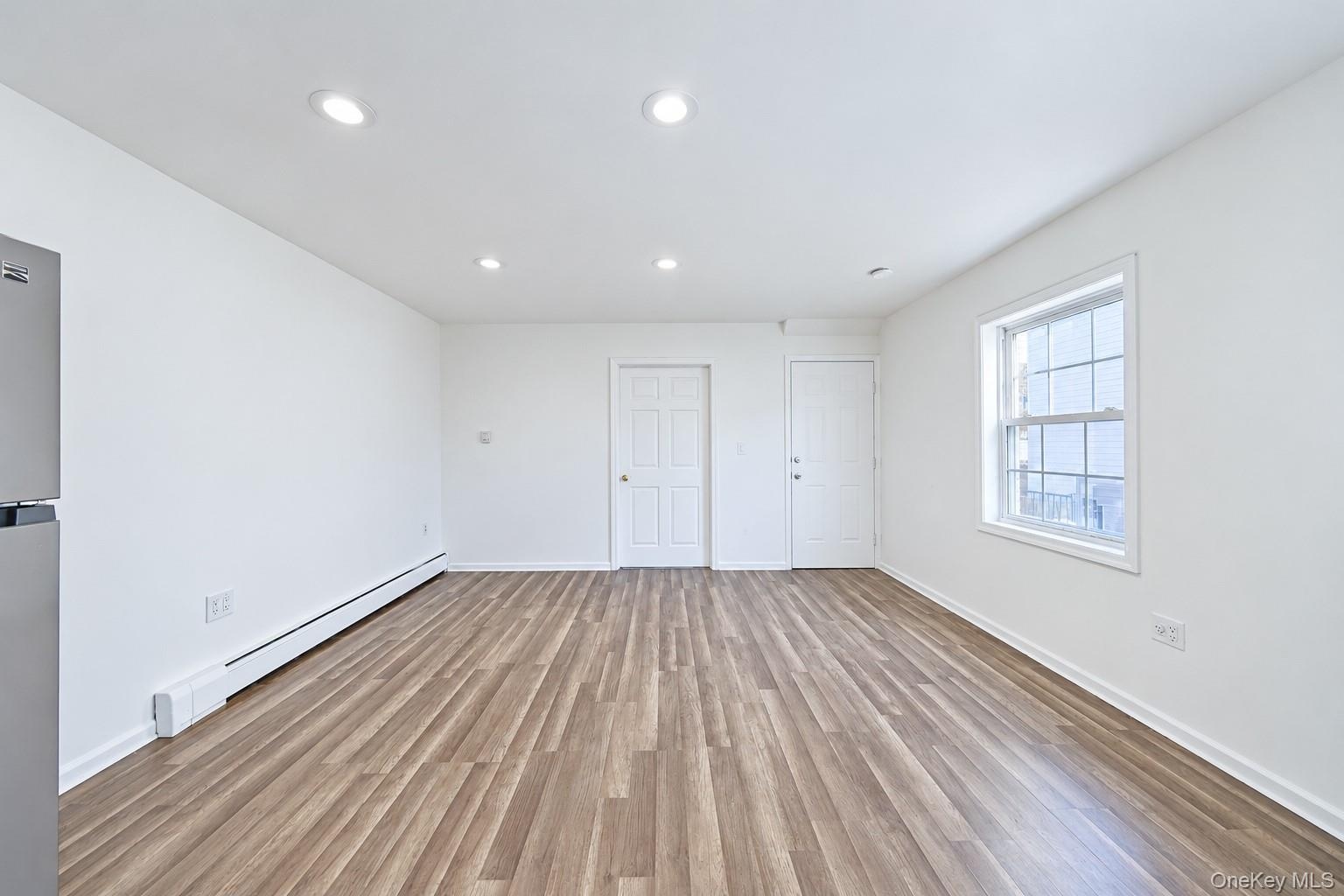 Neutral interior featuring wood-finish flooring, recessed lighting, and a multi-pane window