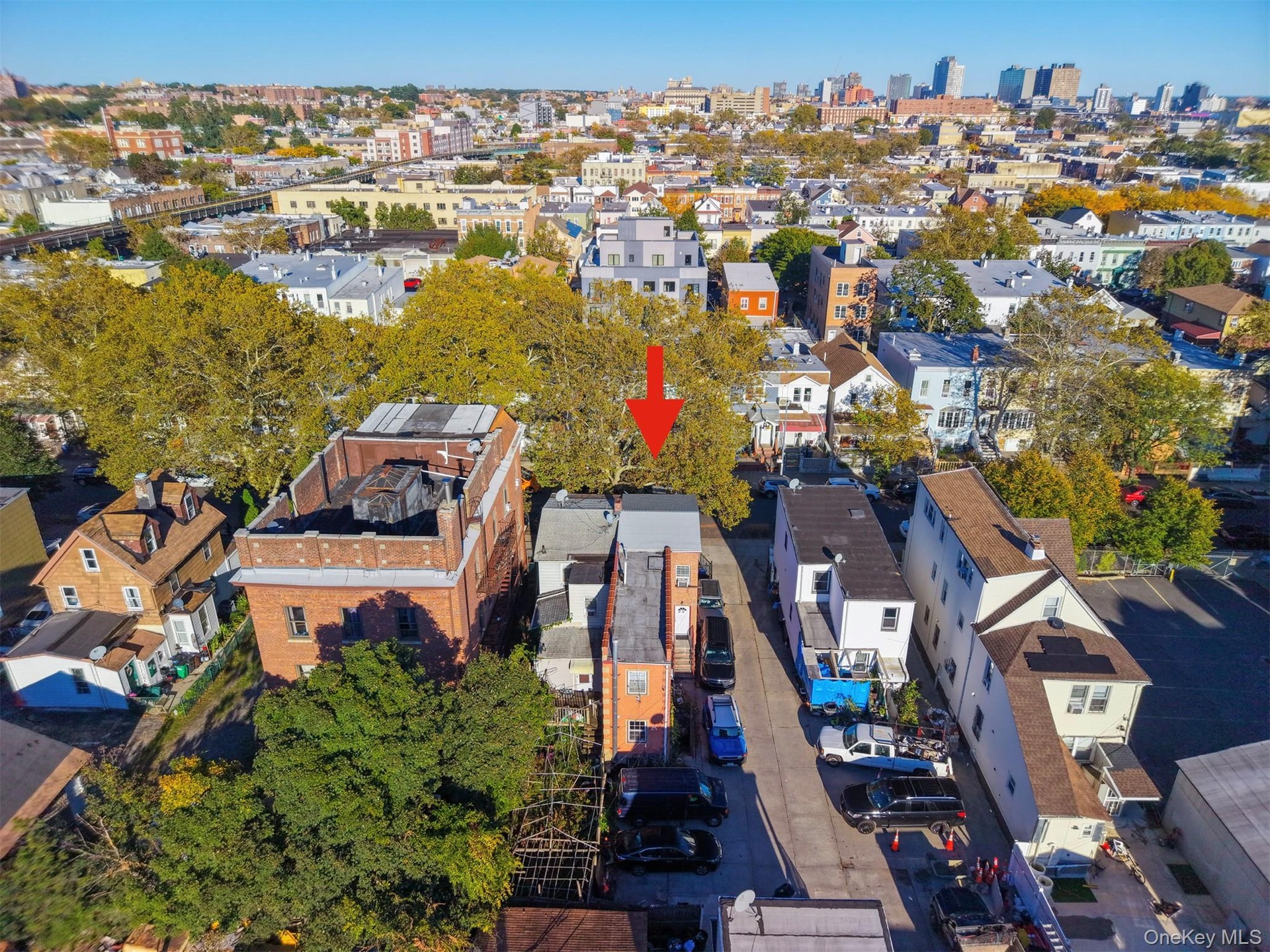 Aerial perspective of a multi-story urban residence featuring a flat roofline, brick masonry exterior, and a secluded rear lot