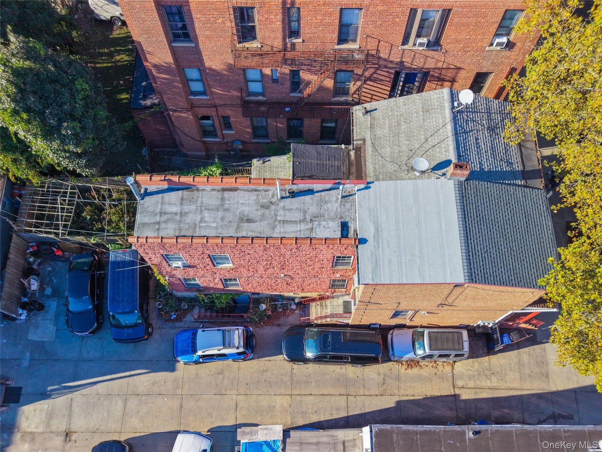 Aerial perspective of a multi-story brick exterior featuring a low-slope roof system and concrete surface parking area