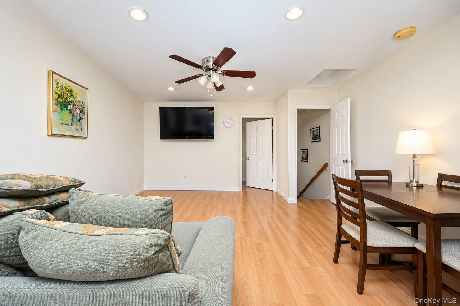 Wood-finish flooring, recessed lighting, and a ceiling fan with integrated lighting fixture